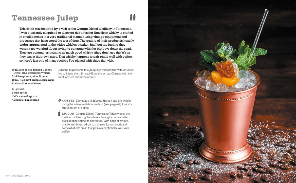 A metal cup filled with crushed ice, garnished with orange peel, mint, and cherries sits on a dark surface scattered with coffee beans and a spilled tin of ground coffee—an inviting scene that perfectly captures the creative inspiration found in The Art & Craft of Coffee Cocktails by Simon & Schuster, ideal for anyone interested in unique coffee cocktails or seeking new cocktail recipes.