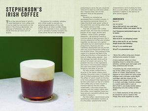 A glass of Irish coffee with a creamy foam on top sits on a dark surface next to a page of text and Simon & Schuster’s Curious Barista’s Guide To Coffee.