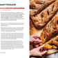 A photo of the King Arthur Baking Company Big Book of Bread by Simon & Schuster open to an olive-rosemary fougasse recipe, with two loaves of sourdough bread on a wooden board and hands tearing a piece from one loaf—a beautiful scene for anyone inspired by classic bread recipes.