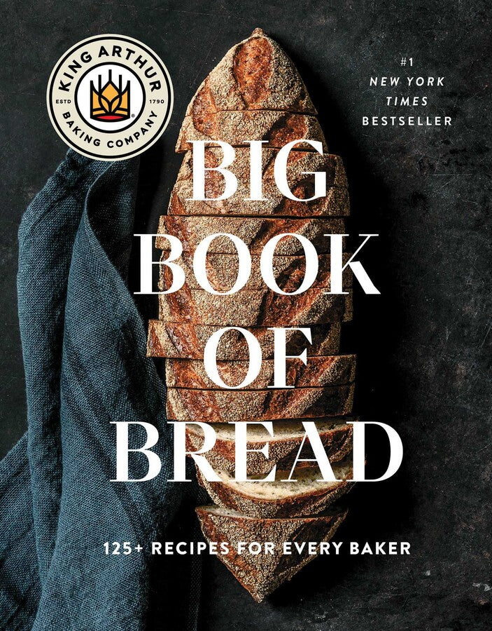 The cover of the King Arthur Baking Company Big Book of Bread, published by Simon & Schuster, showcases a sliced loaf of artisanal sourdough bread on a dark surface with text overlay.