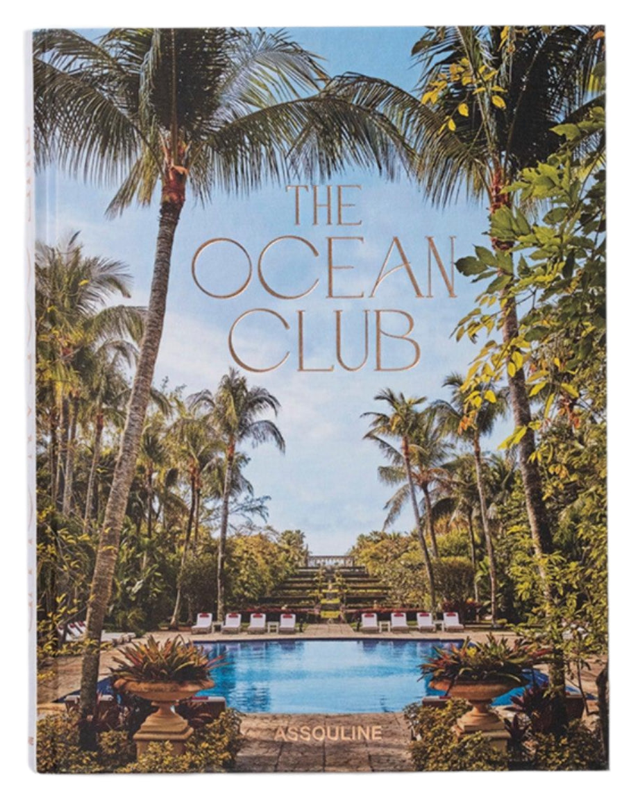 Assouline's "The Ocean Club" book cover beautifully captures the allure of a Bahamian luxury resort, evoking classic Bond movies with its idyllic tropical scene of swaying palm trees and a shimmering swimming pool.