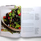 An open copy of Ottolenghi, The Cookbook by Penguin Random House displays a photo of a green salad on the left page and two beet salad recipes with ingredients and directions on the right, capturing the vibrant Mediterranean style typical of Ottolenghi’s celebrated dishes.