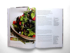 An open copy of Ottolenghi, The Cookbook by Penguin Random House displays a photo of a green salad on the left page and two beet salad recipes with ingredients and directions on the right, capturing the vibrant Mediterranean style typical of Ottolenghi’s celebrated dishes.