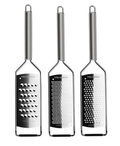 Three Microplane Professional Series 2.0 handheld graters, each with a different grating surface, stand upright against a white background.