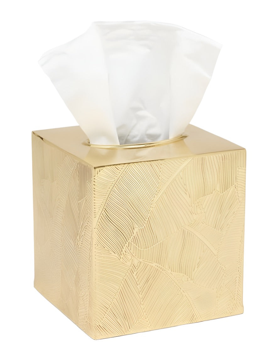 The Pigeon & Poodle Mancora Bath Collection gold-colored tissue box features a textured leaf pattern and shiny finish, with white tissues visible through the top opening.