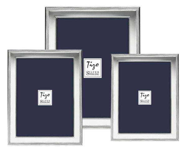 Three photo frames from the Tizo Design's Tizo Sterling Frame with Border Collection, made of sterling silver and featuring navy blue backgrounds, are arranged together. The frames have a thin, textured border, with the one in the center being the largest.