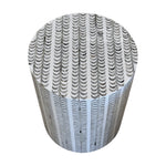 The Bojay Etched Stool features a cylindrical design adorned with a dynamic pattern of repeating curved black and white lines reminiscent of building balconies, creating an eye-catching garden stool and a stylish decorative accent for any outdoor space.