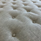Close-up of the HIVE Tufted Ottoman with Table in Landscape Kaki, highlighting its light gray tufted fabric upholstery with evenly spaced buttons and a soft, textured surface.