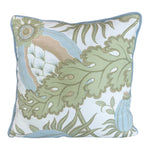 The Associated Design Carnival Celeste Outdoor Pillow features a square shape with a green, blue, and beige botanical pattern on white and piped blue edges, expertly crafted for a luxurious touch.