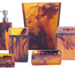 Nashi Home's Tortoise Bath Collection includes vibrant amber and black swirled accessories crafted from Nashi resin, featuring a soap dispenser, tumblers, tissue box, and trays.