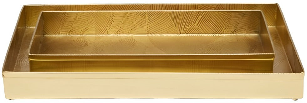 Two rectangular trays from the Mancora Bath Collection by Pigeon & Poodle, crafted in shiny brass—one smaller and nested inside the larger—feature a subtle textured pattern on the base.