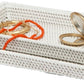 Two white Dalton Bath Collection trays by Pigeon & Poodle, crafted from handmade rattan with organic dyes, are stacked together. The top tray displays a coral bead necklace, gold bracelet, and a round compact mirror.