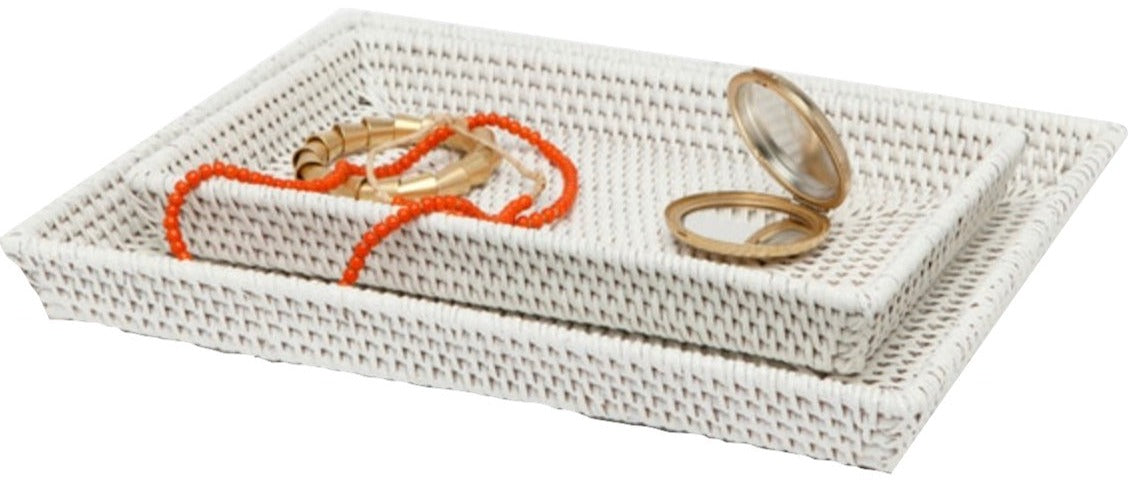 Two white Dalton Bath Collection trays by Pigeon & Poodle, crafted from handmade rattan with organic dyes, are stacked together. The top tray displays a coral bead necklace, gold bracelet, and a round compact mirror.