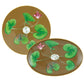The Tresor Fleuri Marron Dinnerware Collection by Raynaud showcases two hand-painted plates with a brown patterned background, green leaves, and pink flowers radiating from a central white circle, capturing exquisite porcelain artistry.