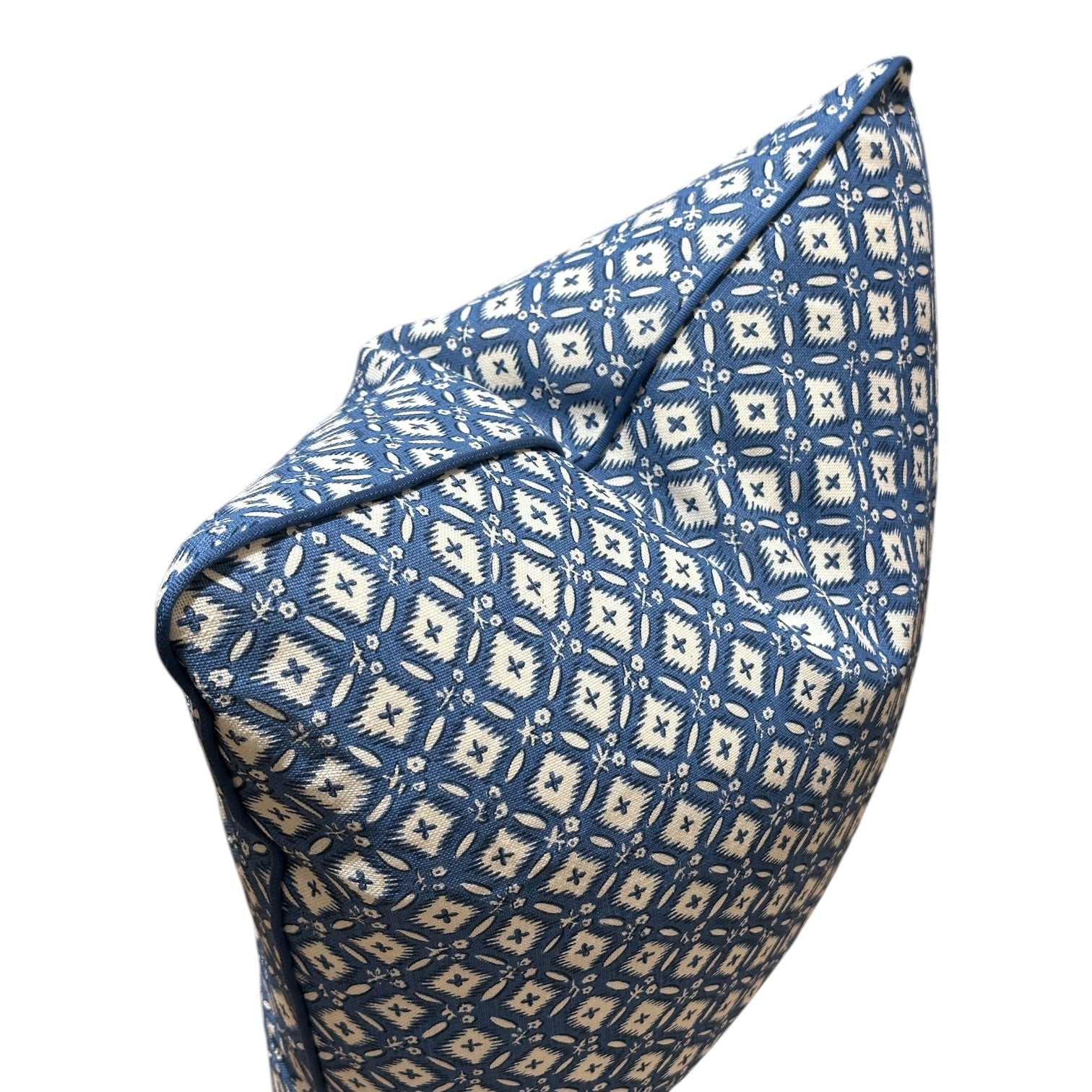 The Tripura Woad Blue Pillow by Hive Custom Pillows features a blue and white geometric diamond pattern, expertly crafted from premium materials and displayed in an angled side view.