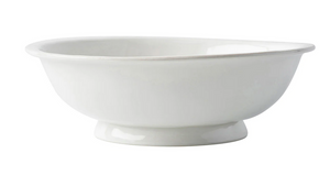 The Juliska Puro Whitewash Footed Fruit Bowl features a wide rim and short pedestal base—ideal for displaying fresh citrus on your countertop. Shown here in plain white ceramic against a white background.