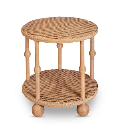 The Lucas Drinks Table by Bunny Williams features a spacious round wicker design with a woven top and lower shelf, four spindle legs, and round feet—perfect as a drinks table. Pictured here against a white background.