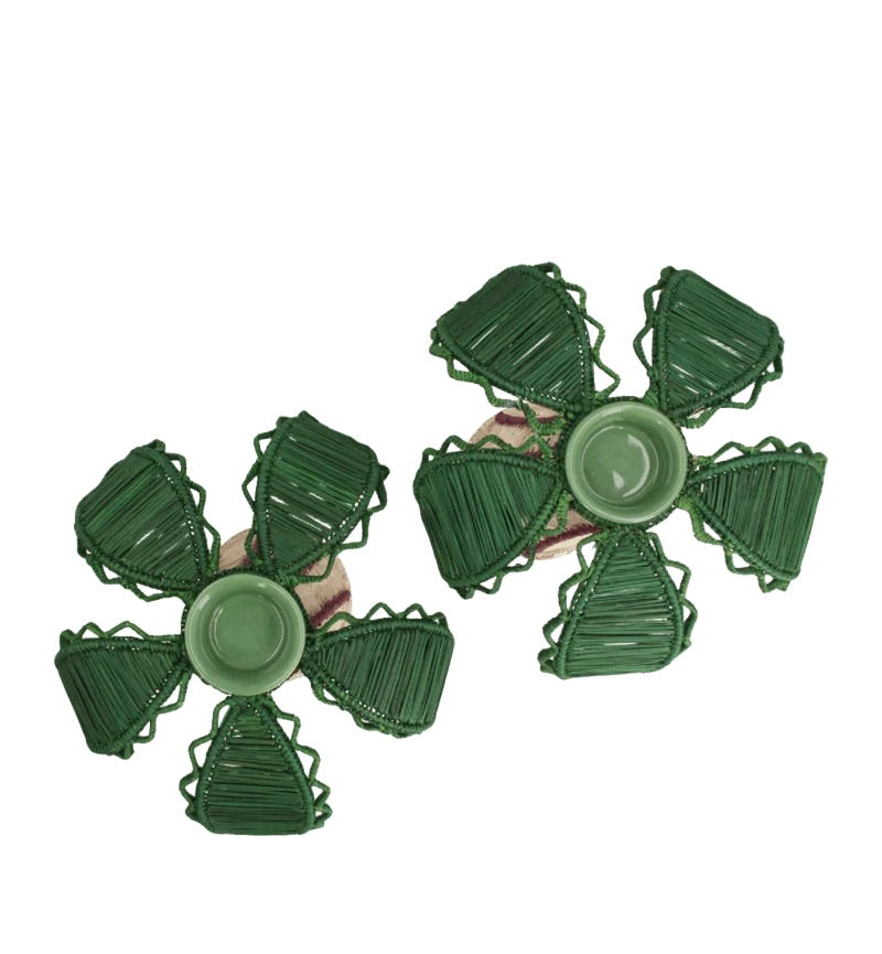 Two green, flower-shaped Palm Candle Holder & Flower Vases by Mercedes Salazar, each crafted from raffia fiber and featuring a central circular section with five petal-like segments, are displayed on a white background.