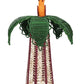The Hoatzin Palm Candle Holder & Flower Vase by Mercedes Salazar is a handcrafted woven sculpture featuring a cone-shaped base, green leaves, and an orange figure reminiscent of a bird or fruit at the top. This exquisite piece serves as artisanal dining decor, perfect for placing atop a table or beside a natural raffia vase to bring warmth and charm to any setting.