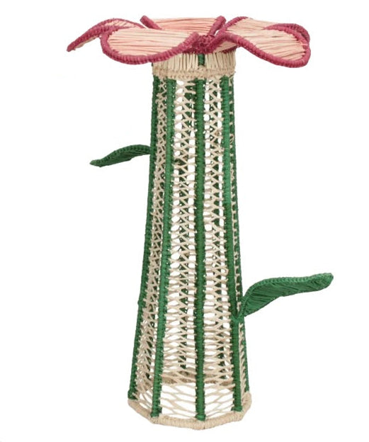 Introducing the Lily Floral Spirit Candle Holder & Flower Vase by Mercedes Salazar, a tall, handcrafted piece fashioned from natural raffia fiber in the shape of a flower stem with green leaves and finished with a pink, flower-inspired rim.