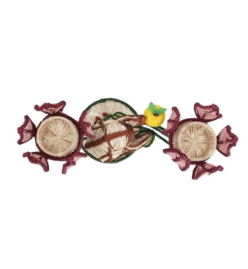 Introducing the Jungle Whisper Mico Candle Holder by Mercedes Salazar: a handwoven raffia decor piece adorned with three round baskets, purple flower shapes, a green stem, and topped with a small yellow bird.