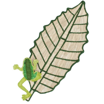 The Mercedes Salazar Frog Leaf Amazonas Tray features an embroidered green frog perched on the edge of a large beige leaf, detailed with dark green outlining and veins, making it a charming accent for any dining setting or handwoven tray crafted from natural raffia fiber.