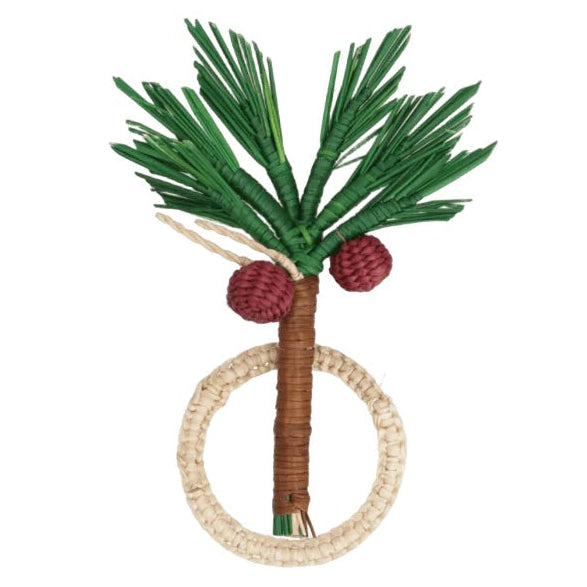 The Coconut Palm Tree Napkin Ring by Mercedes Salazar is handmade in Colombia from natural raffia fiber and features green palm leaves, two red fruits, and a brown trunk attached to a beige circular ring—an exquisite example of the brand's signature napkin rings.