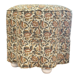The Stella Stool by Bunny Williams features a square shape, earthy floral-patterned fabric cover, and four round wooden feet—ideal as an upholstered stool or cozy footrest.
