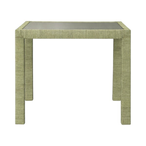 The Isla Game Table in Sage by Made Goods features a square design with a green textured finish and four straight legs, inspired by tropical rattan palms, displayed on a plain white background.