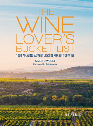Book cover for The Wine Lover’s Bucket List from Rizzoli, displaying a picturesque vineyard landscape beneath a blue sky with rolling hills in the distance, evoking the excitement of wine adventures and inspiring journeys through vineyards.