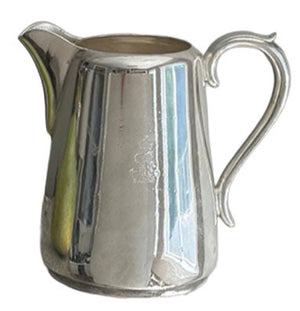 A vintage pitcher with a Cunard Lines badge from Hôtel Silver, featuring a curved handle and spout that reflects light and surroundings, evoking classic elegance.