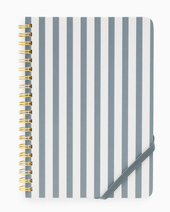 The Sugar Paper Mini Spiral Notebook showcases vertical gray and white stripes, elegant gold coil binding, and is secured with a gray elastic band at the bottom right corner. With lined pages inside, it’s perfect for jotting down your daily to-do lists.