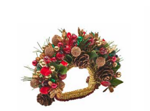Kim Seybert Tinsel Bow Napkin Ring decorated with pinecones, red berries, and metallic holiday ornaments for Christmas table decor.