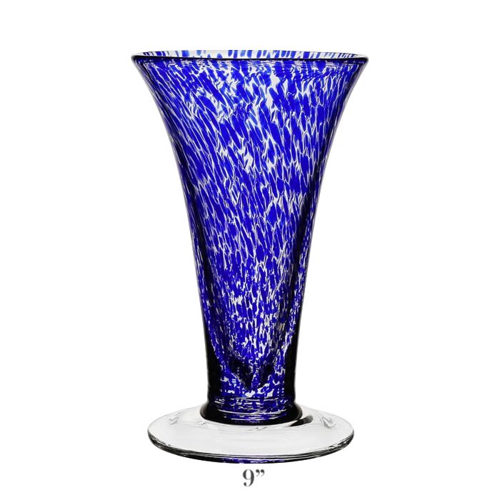The Vanessa Vase Collection by William Yeoward Crystal showcases handmade blue and white speckled glass with a flared rim and clear base, evoking Mediterranean charm. Stands 9 inches tall.