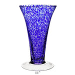 The Vanessa Vase Collection by William Yeoward Crystal features a tall, flared handmade crystal vase in Mediterranean blue with white speckles, clear round base, and 11-inch height.