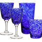 Four blue glasses from the William Yeoward Crystal Vanessa Blue Drinkware Collection, featuring two wine glasses and two tumblers with a stunning textured design, are displayed against a white background.