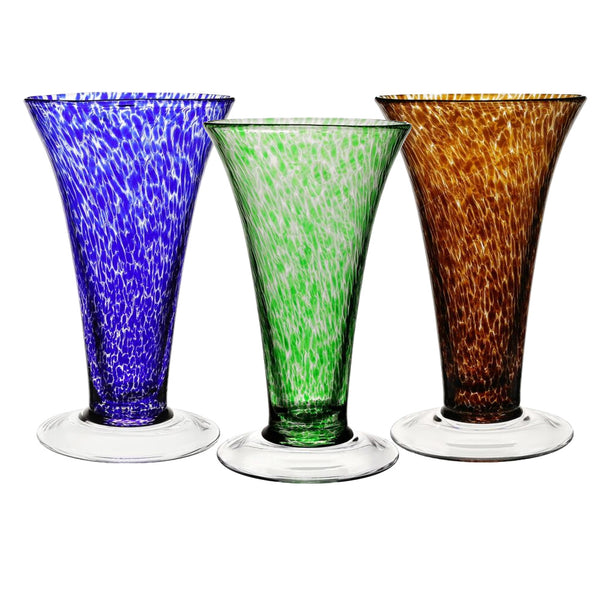 The William Yeoward Crystal Vanessa Vase Collection presents three tall glass vases with blue, green, and brown speckles. Their wide brims and clear bases reflect the elegance and handmade crystal craftsmanship synonymous with the brand.