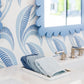 A tray with folded blue washcloths rests on a white countertop near a sink, accented by the Fleur Home Garden District Coquette Rectangle Mirror in Denim Wash and patterned wallpaper inspired by New Orleans charm.
