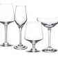 Four empty glasses from the Simon Pearce Vintner Drinkware Collection—a red wine glass, handmade flute, white wine glass, and coupe—stand elegantly on a white background, reflecting Napa Valley winemaker style.