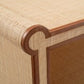Close-up of the Matthew Coffee Table by Made Goods, showcasing its uniquely shaped corner, woven raffia surface, and dark full-grain leather trim.