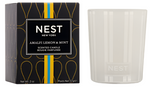 The Nest Amalfi Lemon & Mint Collection candle comes in a white jar with packaging inspired by the Amalfi Coast, featuring a black box adorned with yellow and blue accents.