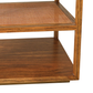 The Orca Side Table by Julian Chichester showcases two wooden shelves—an upper shelf with an antiqued rattan surface and a lower shelf finished in smooth wood grain—all elegantly supported by an aged brass base inspired by refined African Walnut furniture.