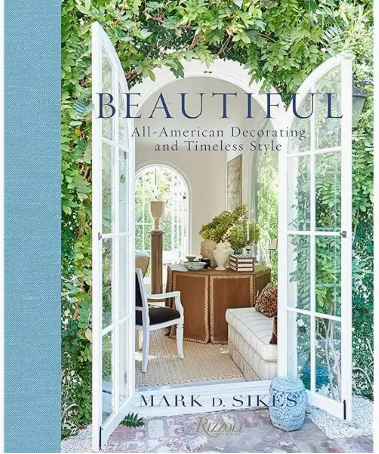 Cover of the book “Beautiful” by Rizzoli, featuring an open doorway that reveals a stylish, sun-drenched living room adorned with classic décor and lush greenery above—a striking example of American-style interiors and the seamless indoor/outdoor lifestyle of California.
