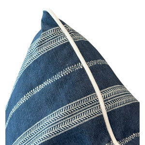 A close-up of the Orlando Stripe Outdoor Pillow by Associated Design, featuring blue fabric with white embroidered horizontal stripes and a crisp white piped edge, crafted from premium materials.
