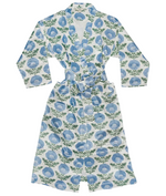 Sure! Here’s the revised sentence using your product data: The Kaavia Robe by John Robshaw is a white mashru silk cotton robe with long sleeves and a belt, adorned with blue floral and green leaf motifs inspired by Jaipur’s iconic floral block print.