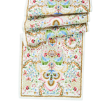 The Sofia Table Runner by Juliska is a folded, rectangular linen runner featuring intricate floral and geometric patterns in pastel pink, blue, green, and gold on white—ideal for spring table decor.