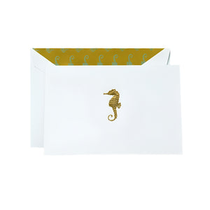 Send your notes in style with Crane’s Gold Seahorse Classic Card Set, featuring white cotton paper envelopes, gold engraved seahorses, and a yellow inner lining with a repeating seahorse pattern.