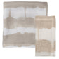 Two folded 100% linen napkins from Kim Seybert's Watercolor Stripe White/Natural Linen Collection are displayed side by side on a white background—perfect for your summer dining table.