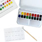 The Emily Lex Studio Watercolor Paint Set includes 18 watercolor paints in a metal tin, a color chart card, and a paintbrush, all thoughtfully arranged on a white surface—making it the ideal travel kit for painting on the go.