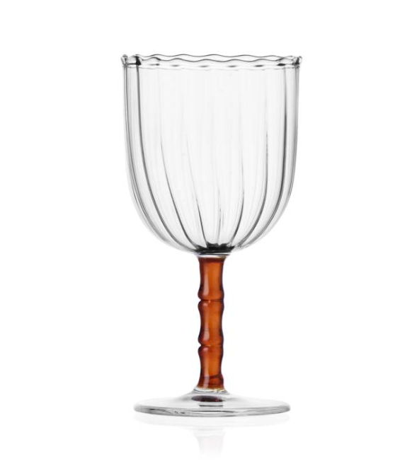 The Rivoli Drinkware and Tealight Collection by Ichendorf Milano features a clear ribbed glass goblet with a wavy rim, short amber stem, and round base—an elegant example of hand-crafted glassware.